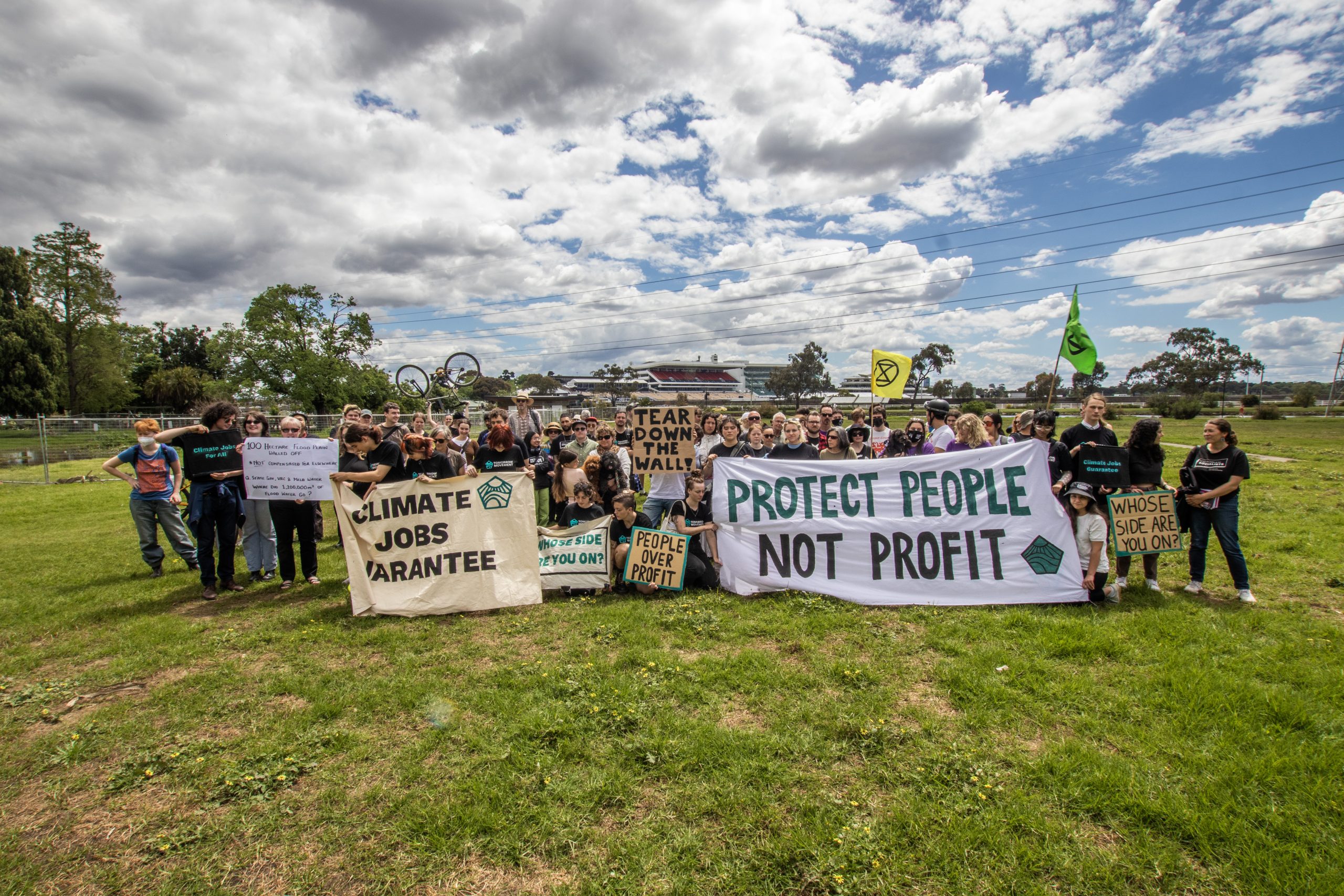 Group photo of crowd of people at the Tomorrow Movement 2022 COP27 Melbourne Action . Banners says people over profit