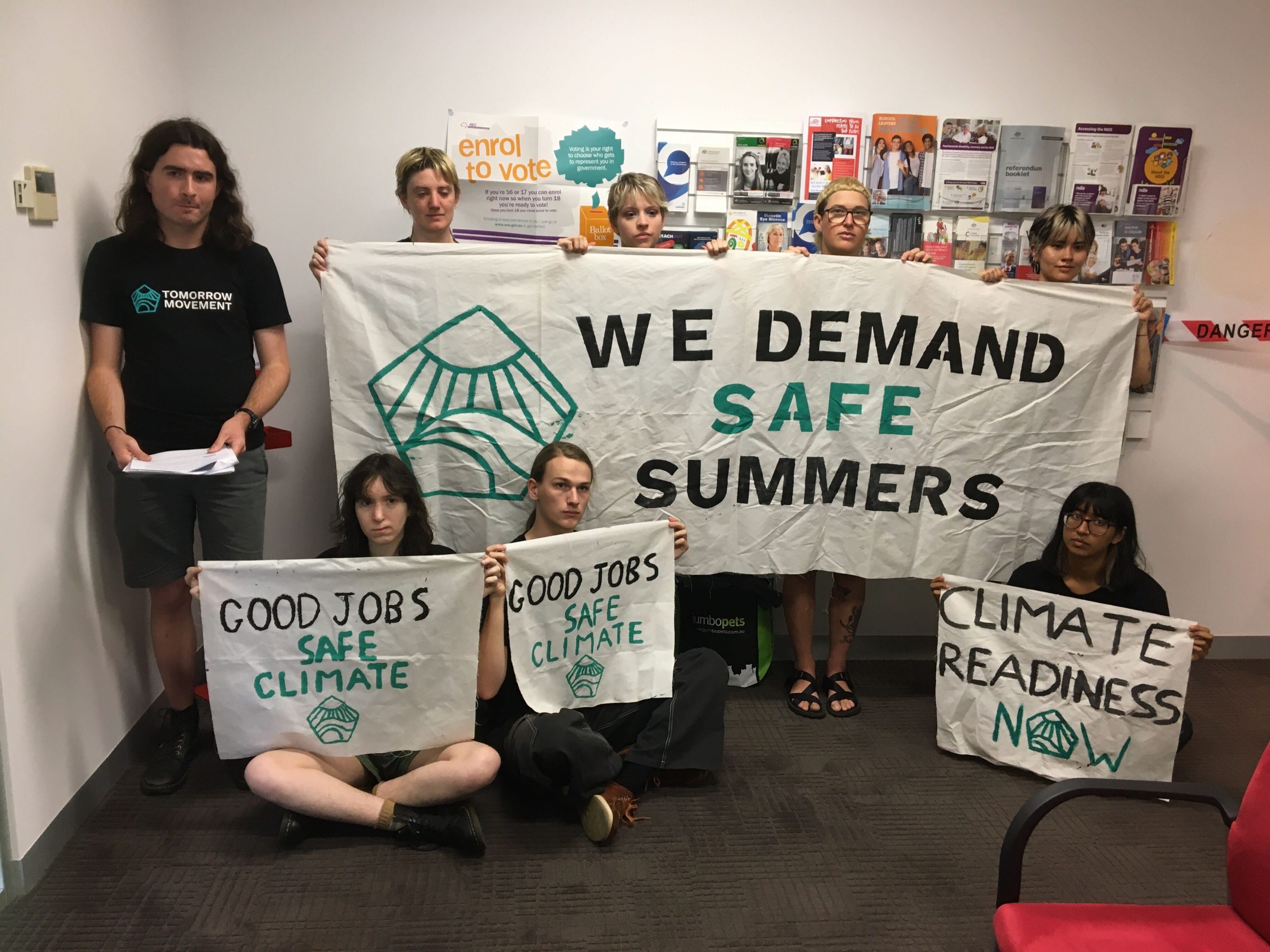 Young people holding a we hold a we demand safe summer banner
